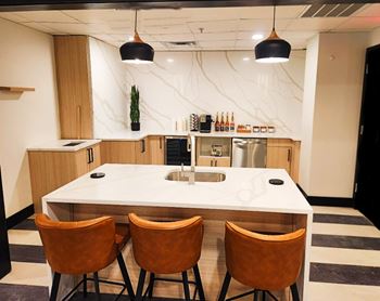 Clubroom featuring coffee bar, business center, tv/media area, game area, and kitchen
